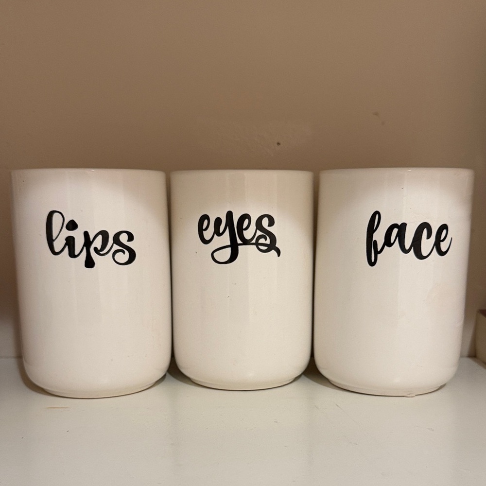 White ceramic canister set w/ text:lips,eyes,face. Perfect to make up counter